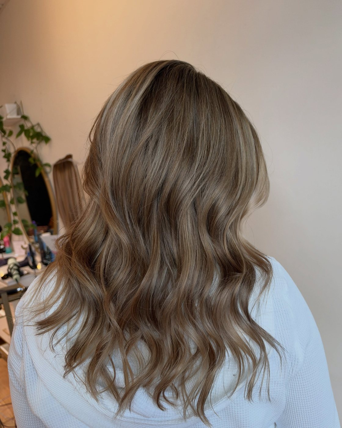 A soft dimensional blonde by Emma Cappuccilli, seen from behind in loose waves, at Canterbury & Co. in Fort Myers.