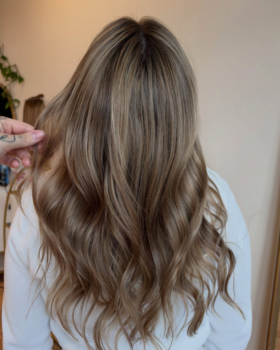 After: a soft, dimensional blonde with a blended root, finished in loose waves
