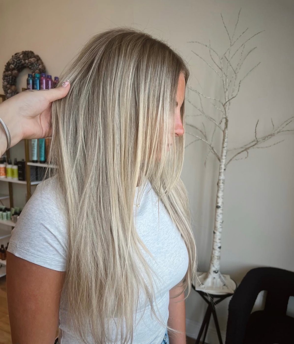 Sleek, glossy creamy blonde long hair catching the light, showing high shine and even tone