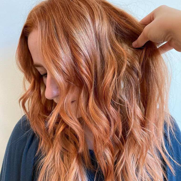 Vivid copper-red hair in lived-in tousled waves