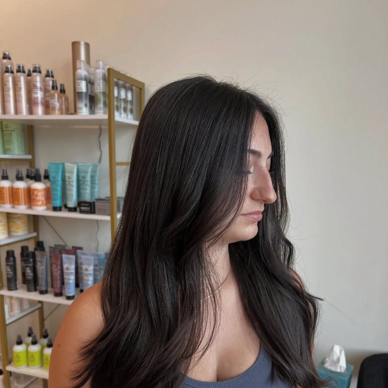 Espresso-brown glossed hair with long flowing layers and a soft bend through the ends