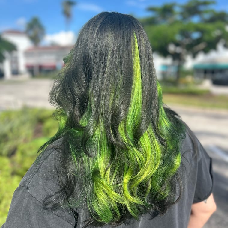 Lime-green peekaboo color through long black hair in loose waves, seen from behind. Vivid color by Tori Knox at Canterbury & Co. Salon in Fort Myers