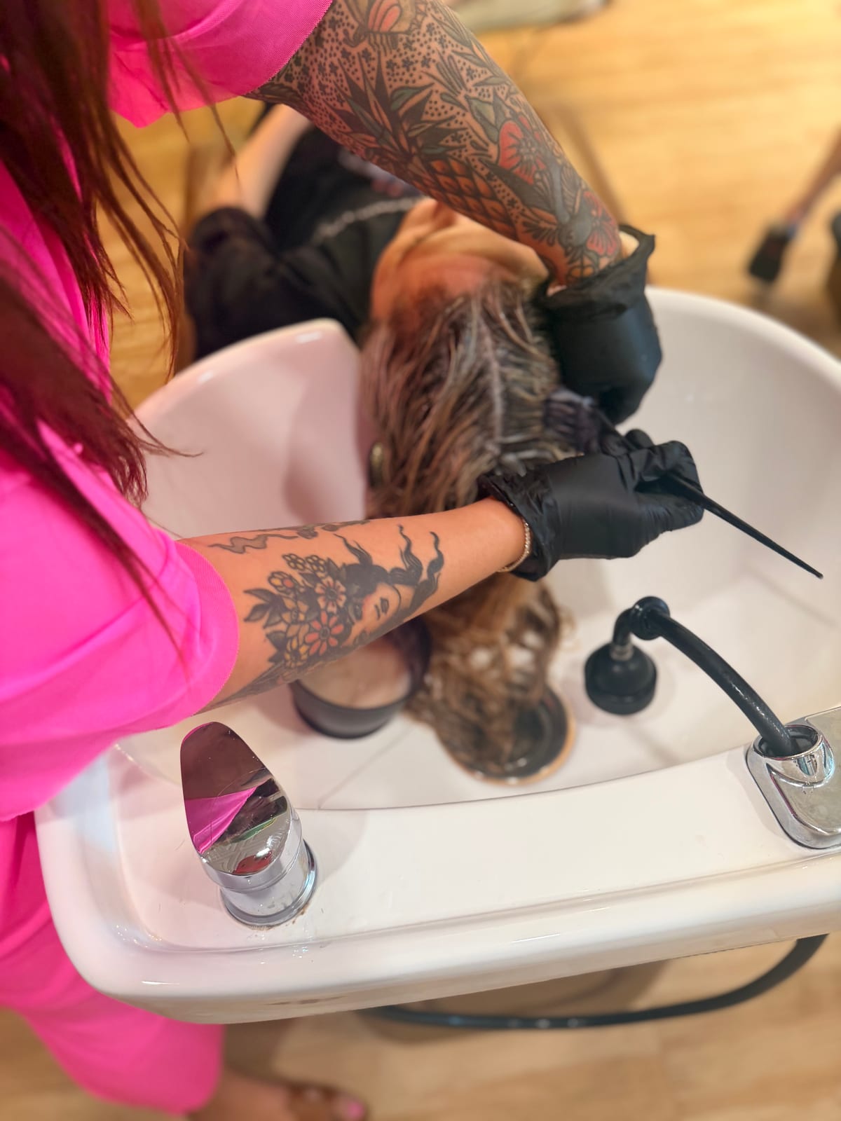 A stylist rinsing a blonde client’s hair at the backwash at Canterbury & Co. in Fort Myers.