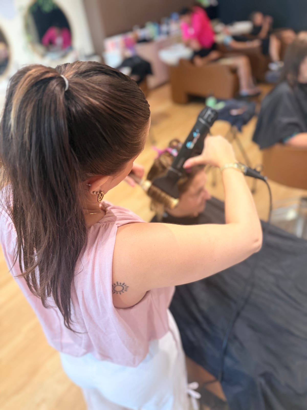 A stylist finishing a blow-dry with a round brush at Canterbury & Co. Salon, Fort Myers.