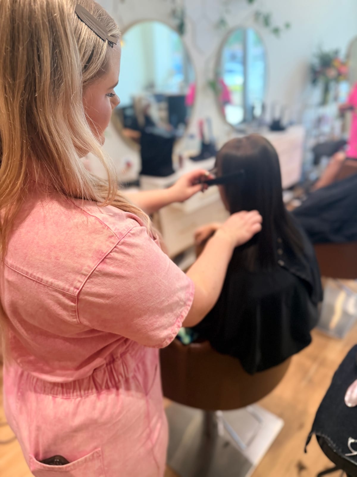 A stylist sectioning long brunette hair with a tail comb before colour at Canterbury & Co.