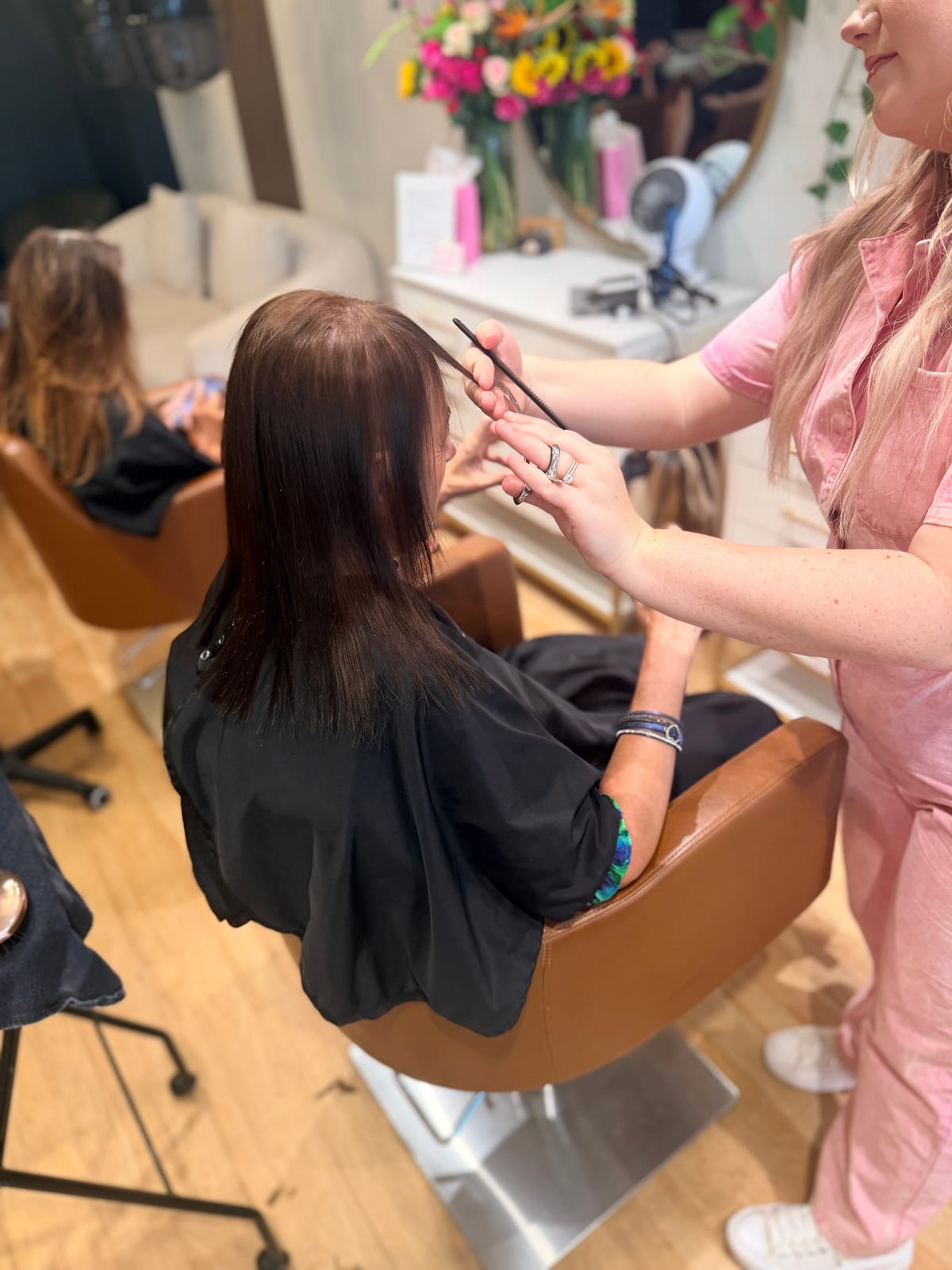 A Canterbury & Co. stylist taking a clean section with a tail comb before colour.
