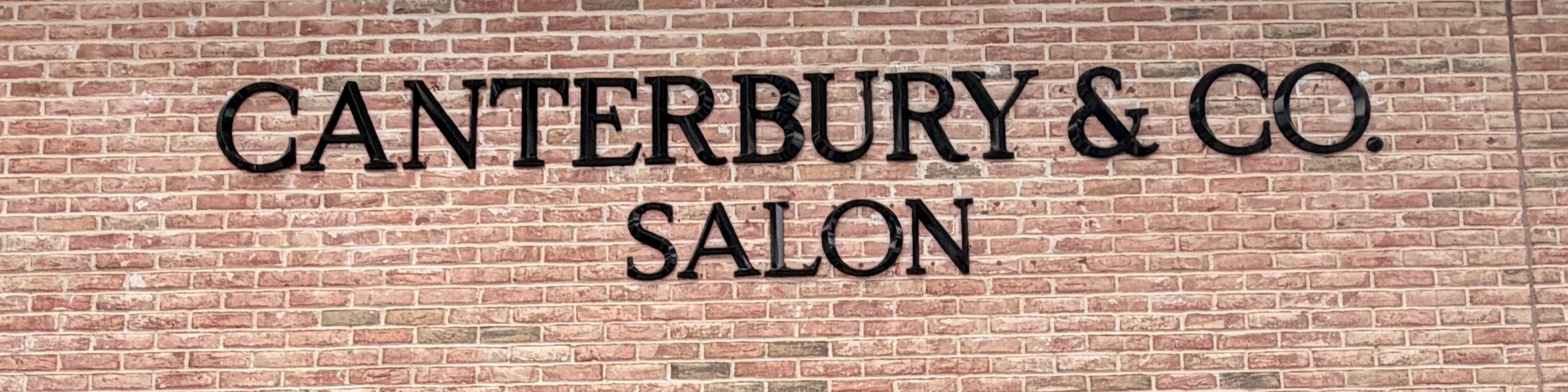 The Canterbury & Co. Salon sign on the brick facade at Gulf Coast Town Center, Fort Myers.