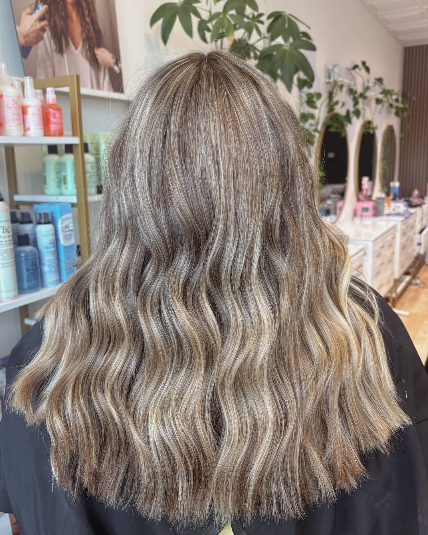 After: the same hair brightened to a soft beige blonde, finished in loose waves