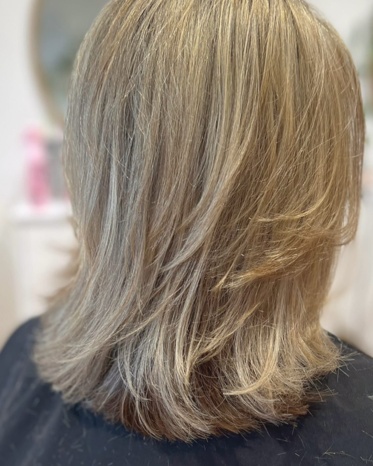 After a haircut: the same blonde hair trimmed with soft layers and movement through the ends, at Canterbury & Co. in Fort Myers
