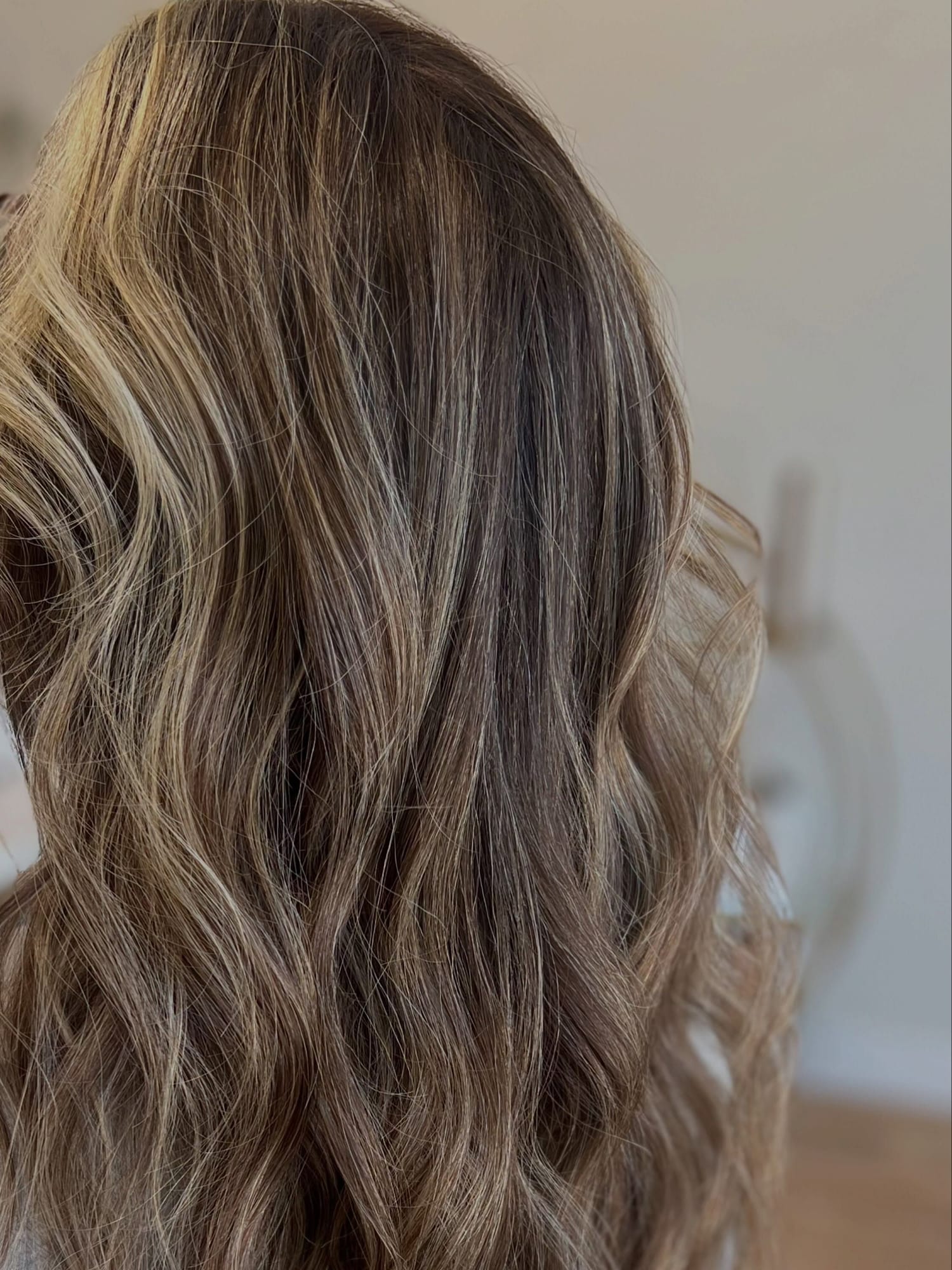 Close view of lived-in bronde color, soft caramel and beige pieces through brunette waves, at Canterbury & Co. in Fort Myers