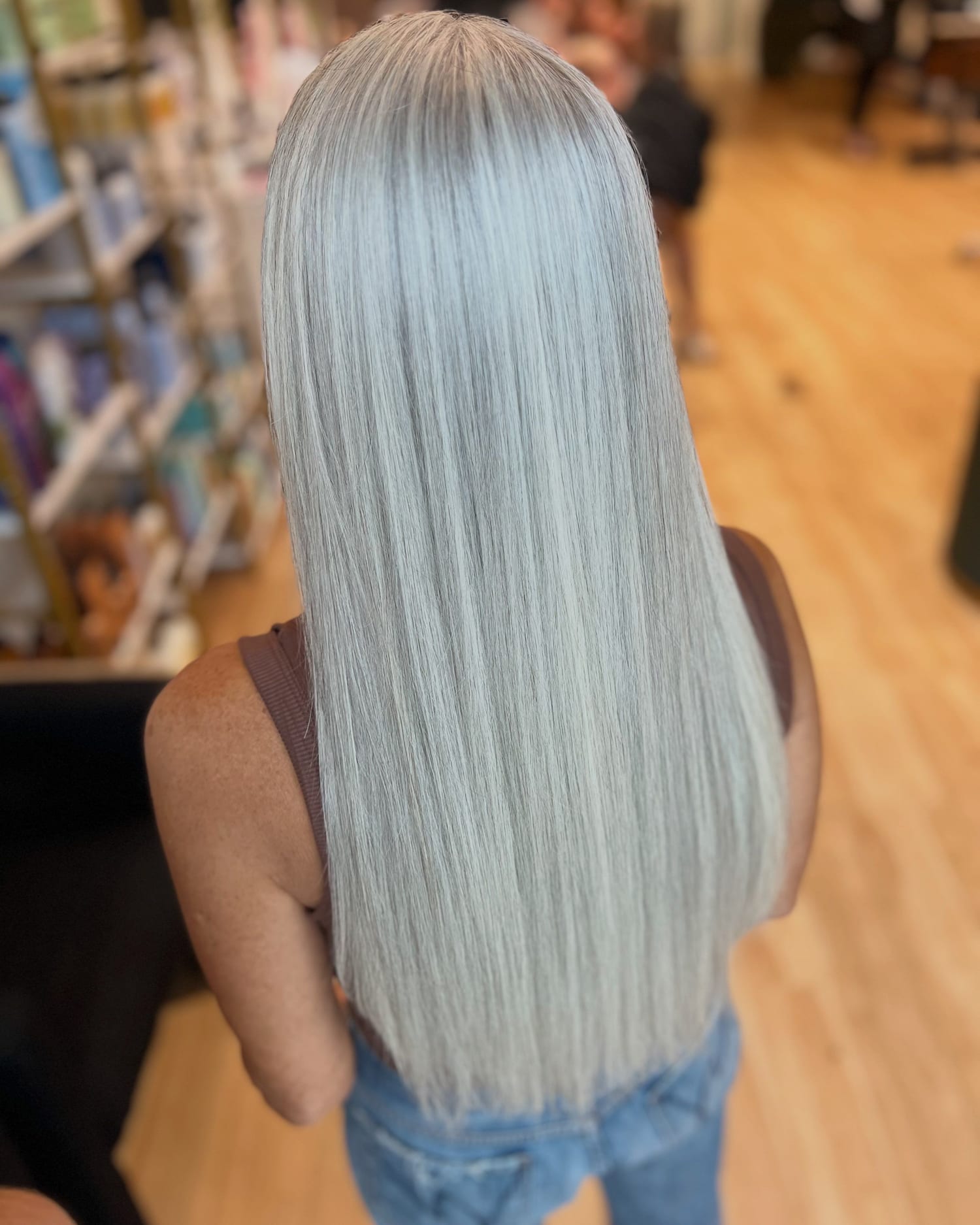 Long, straight, silver-grey hair with no color, smoothed with a Brazilian Blowout, seen from behind at Canterbury & Co. in Fort Myers